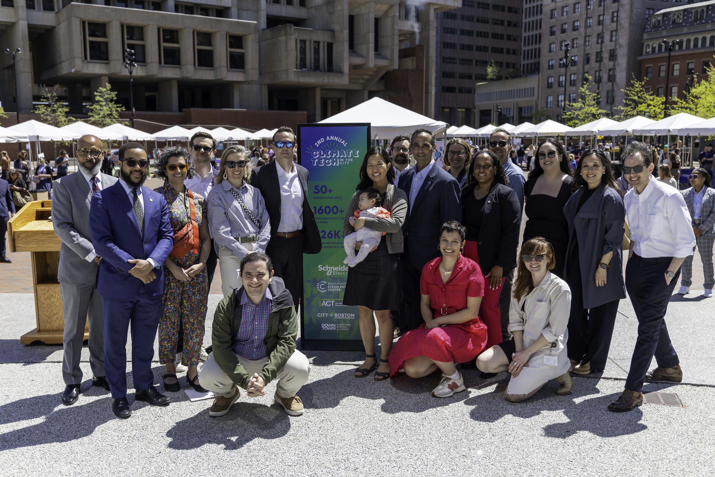Leaders in Boston stand together, smiling, at Climate Tech on the Plaza.