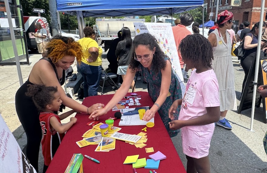 A Common SENSES Team member guides Boston residents through an environmental sensor activity.