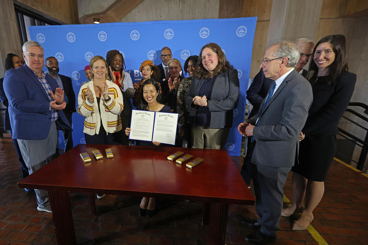 Mayor Wu at the signing ceremony surrounded by City staff, City Councilors, and advocates.