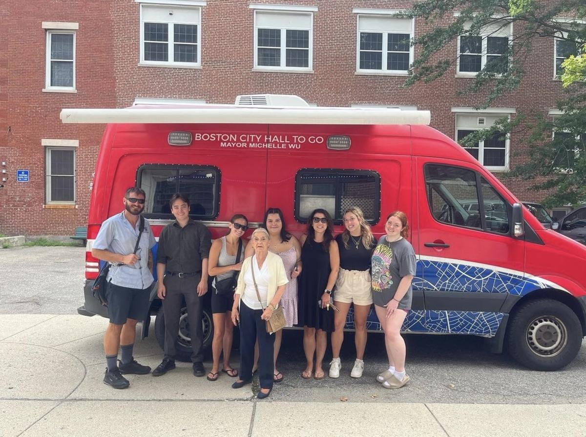 Community Members stand in front of the City Hall on the Go Truck 