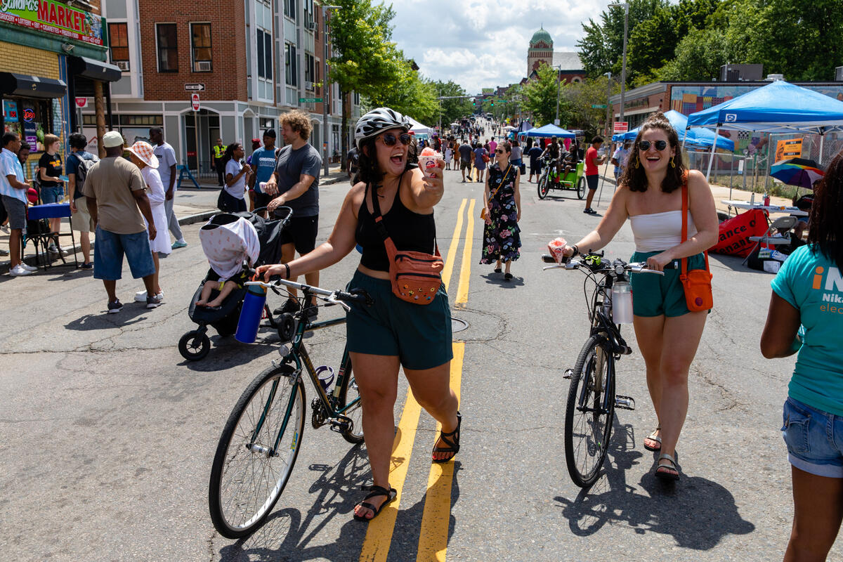 a photo showing people walking and socializing on a pedestrianized street with tents lining the roadway 