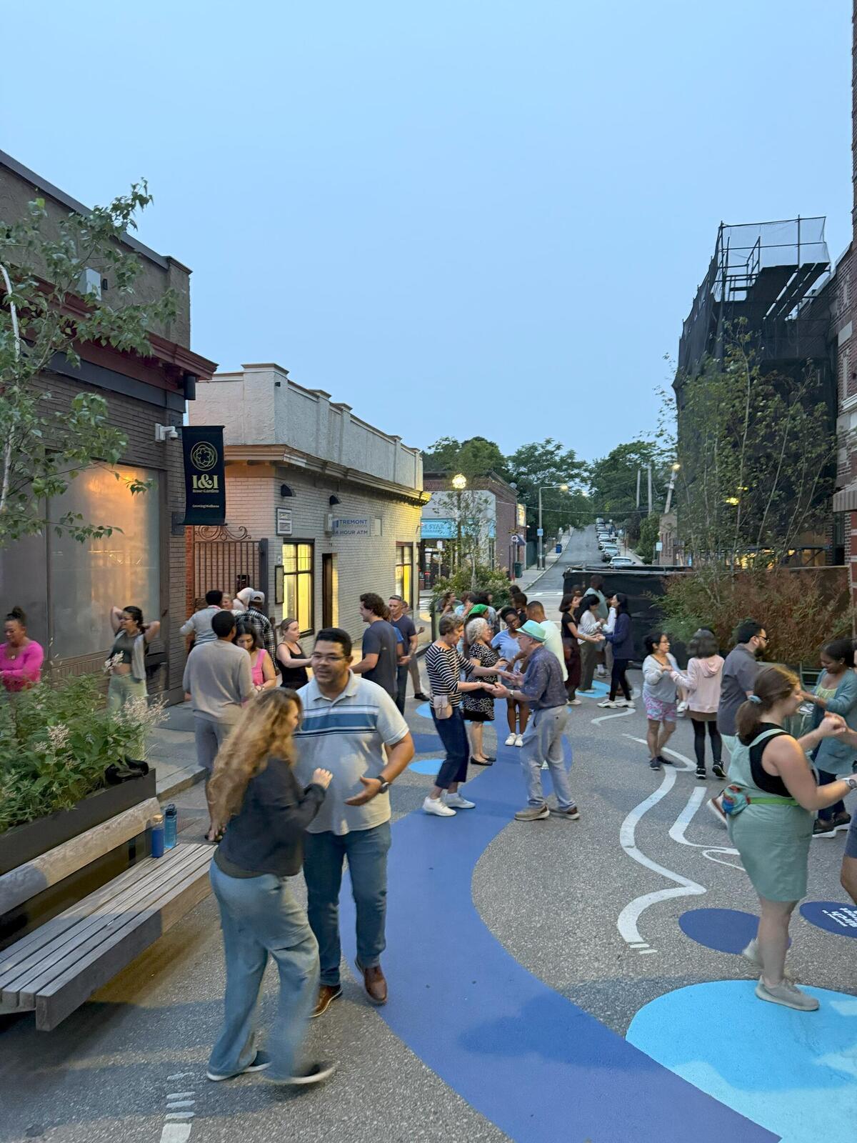 A photo showing a group of people salsa dancing in a pedestrian plaza 