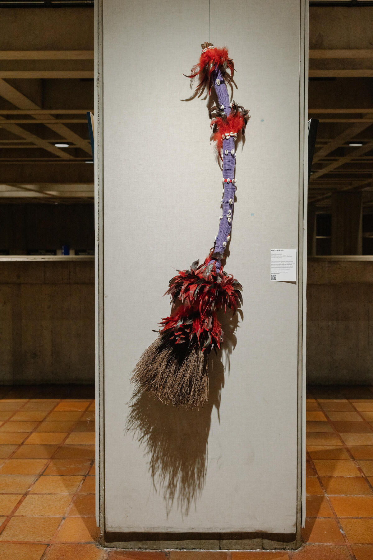 Pam Goncalves,&nbsp;Ritual Broom, 2023, Wood, broom straw, fabric, feathers, cowrie shells, 48 in.