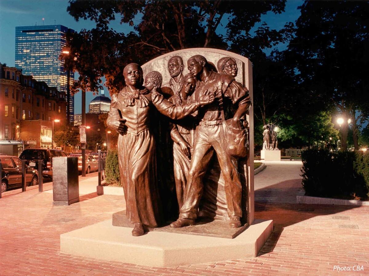 A statue depicting Harriet Tubman leading a group of people is pictured.