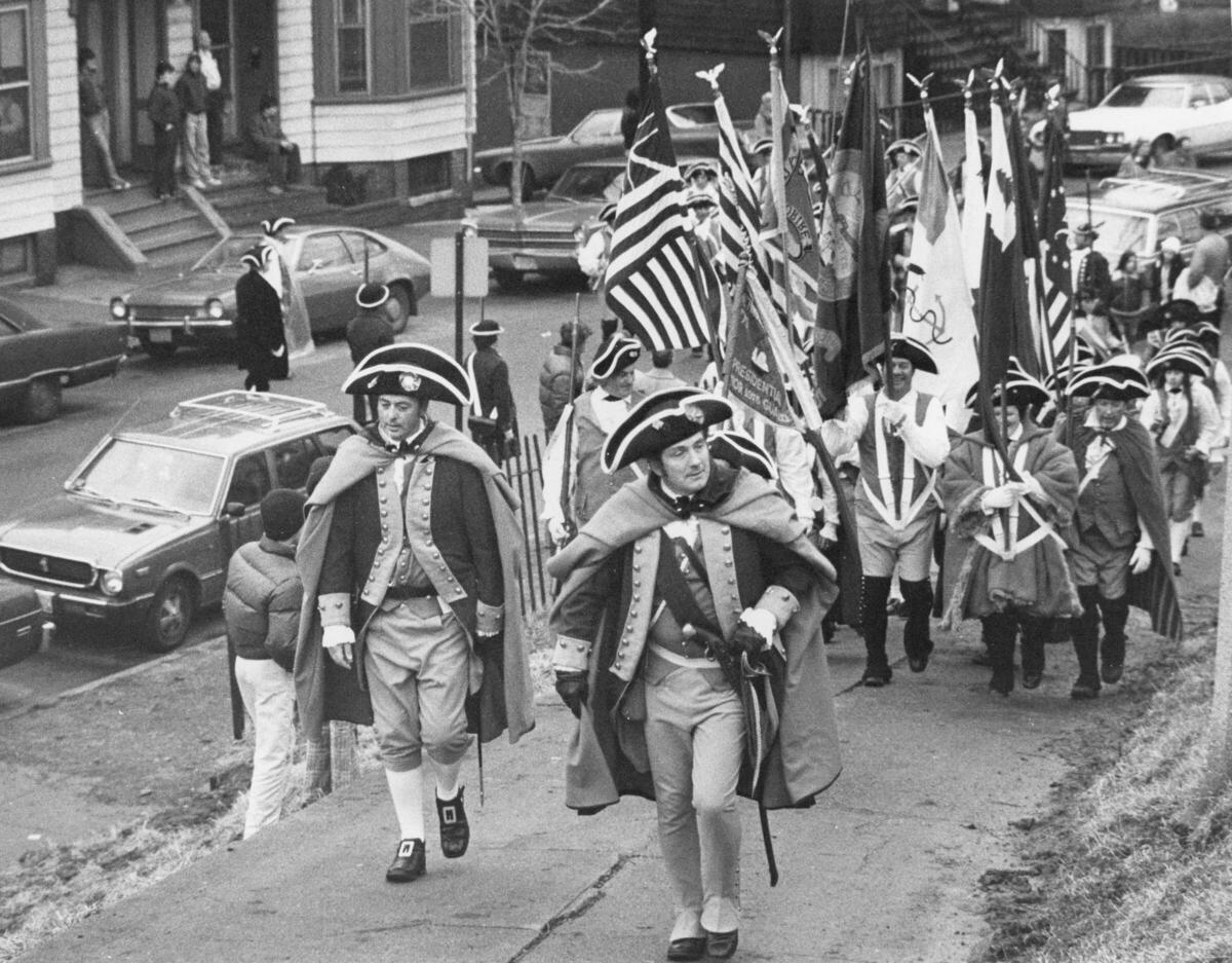 Individuals dressed as Continental soldiers marching in the 1976 Evacuation Day reenactment