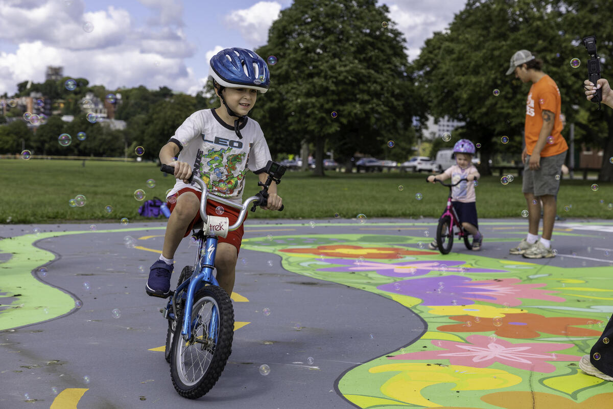Child biking at Moakley Park bike town
