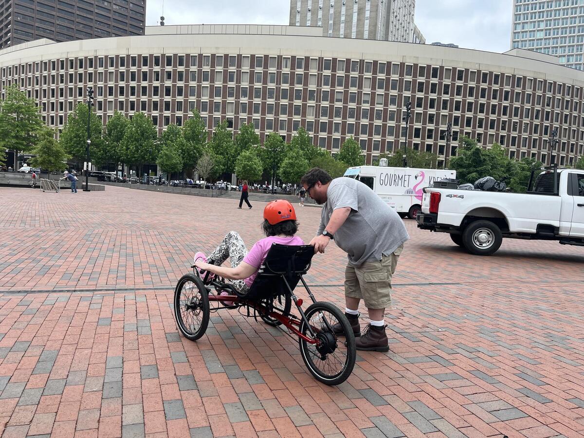 an adult with disability test-riding an adaptive bike
