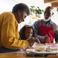 Grandparents baking cake with granddaughter