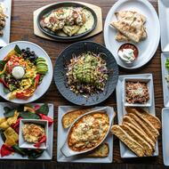 Overhead view of a restaurant table spread with a variety of appetizers and entrees