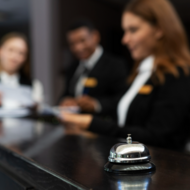 Blurred image of hotel workers with bell in focus