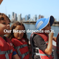 Children in life vests enjoying the sunshine on a boat in Boston harbor.