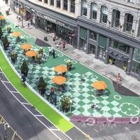 An aerial photo showing a tactical pedestrian plaza on Franklin Street in Downtown Boston featuring temporary curbing, planters, barriers, pavement graphics, and street furniture